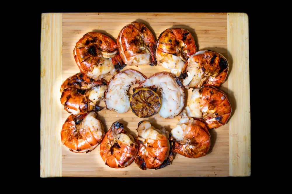 Grilled jumbo shrimp on bamboo board with charred lemon