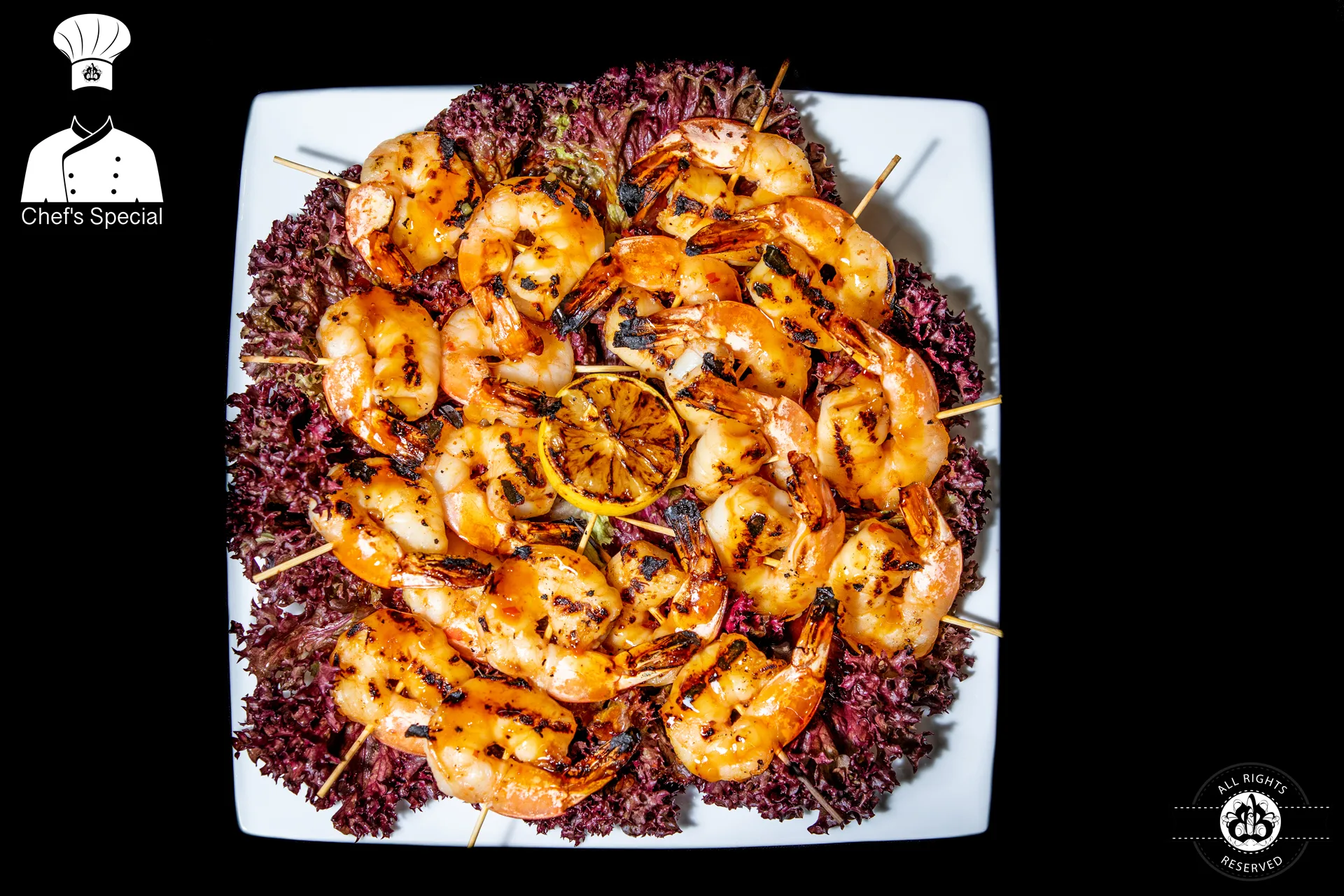 Grilled shrimp skewers on bed of purple lettuce