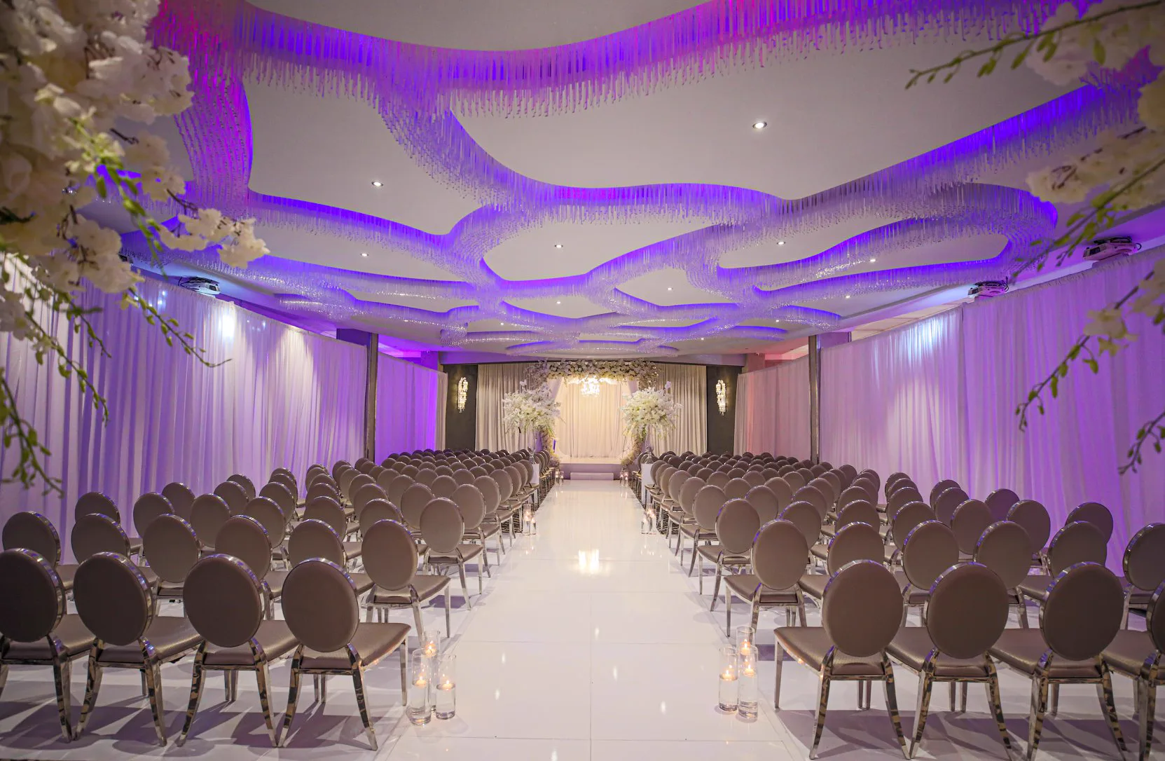 Crystal Ballroom — ceremony setup with orchid aisle and oval chairs